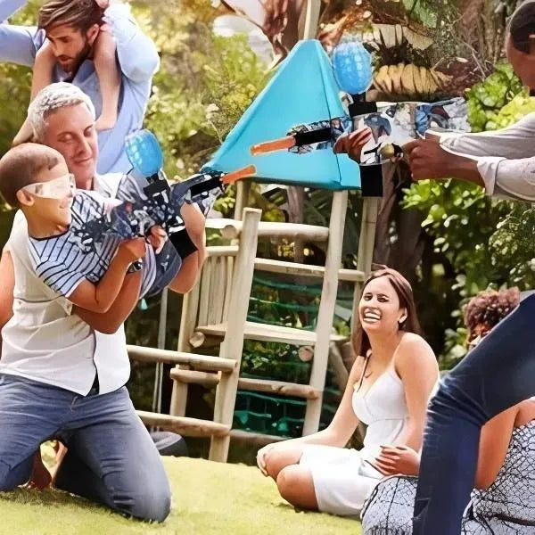 Family outdoors with children playing with water guns, surrounded by greenery.
