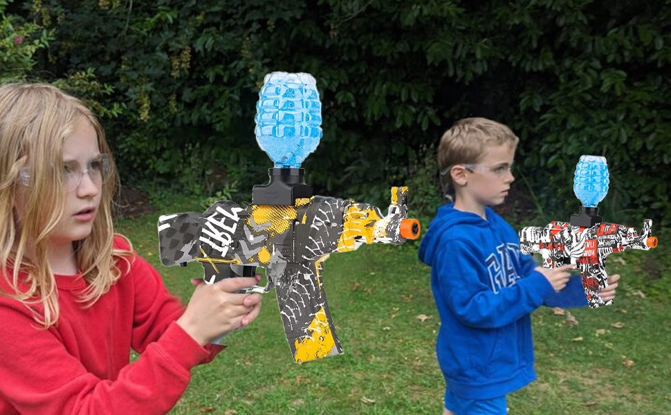 Two children playing with a gel blaster ammo on the grass.